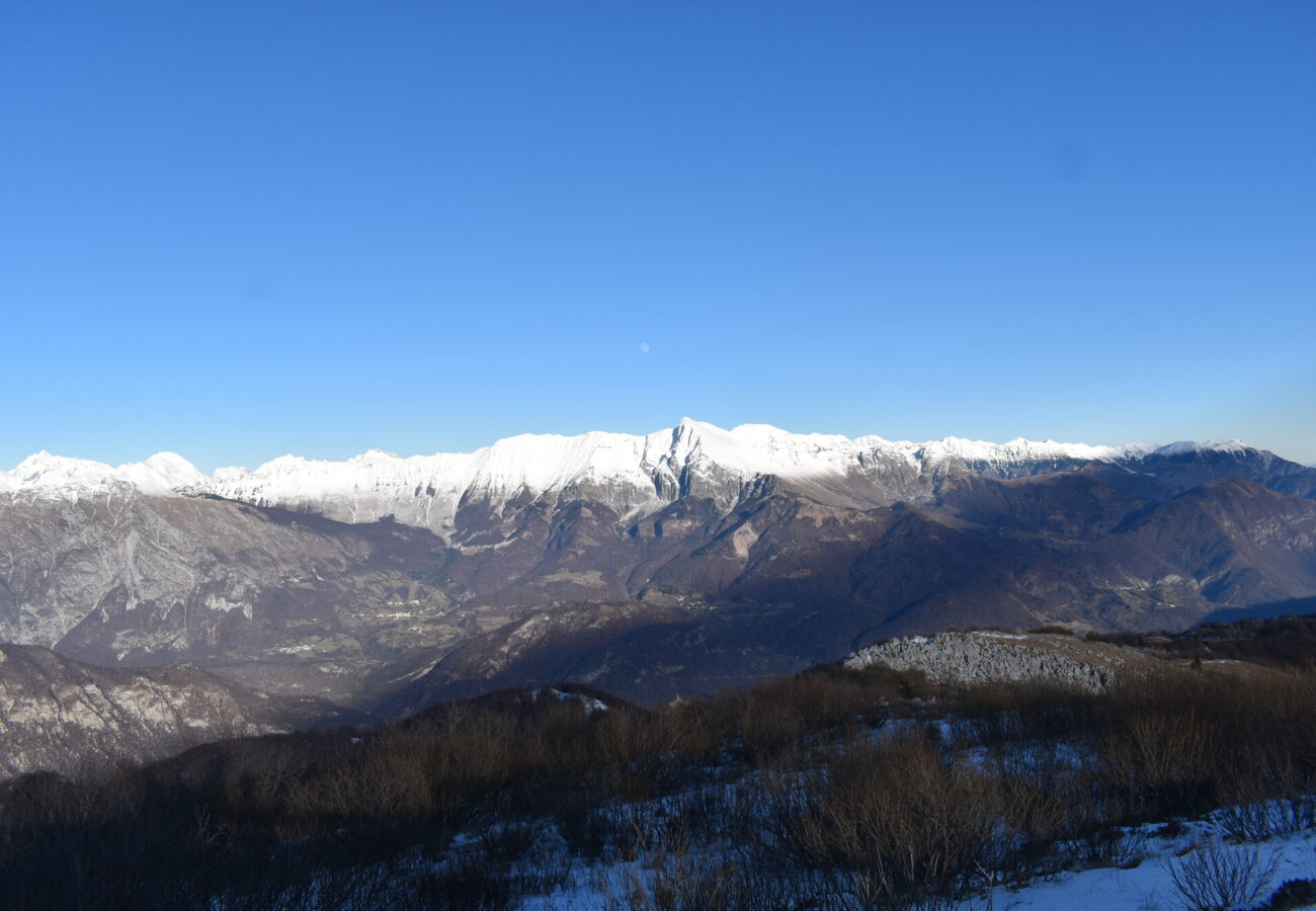 Panoramica di montagne ricoperte di neve con vista di cielo con la luna
